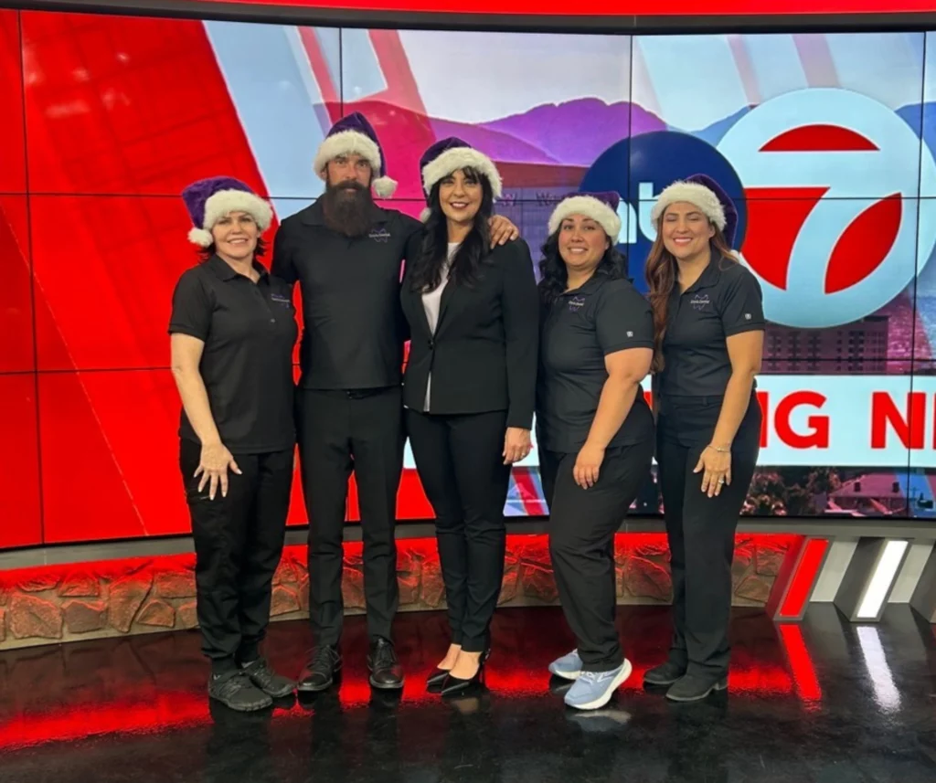 The Davis Dental team in holiday hats at a local TV news studio