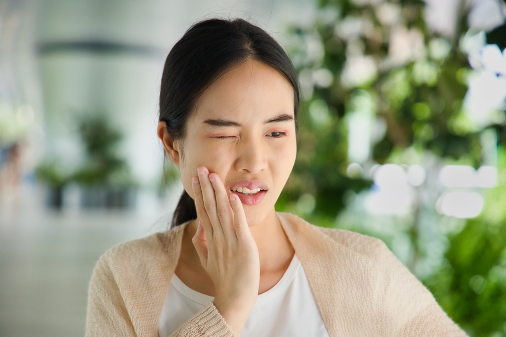 Woman holding her jaw in pain